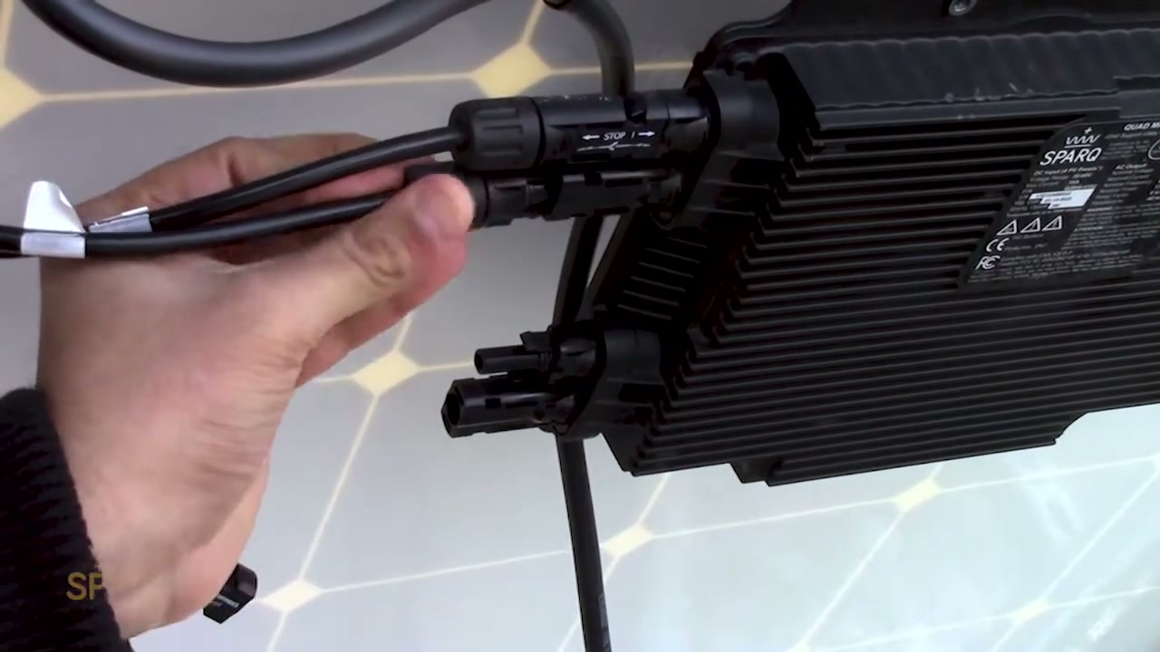 A panel's DC lead being pushed into the Quad's input connector by hand