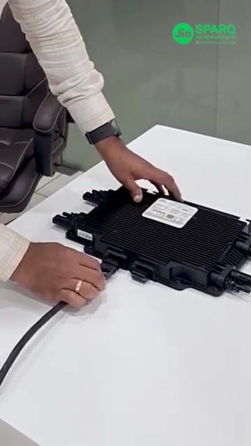 A Quad microinverter on a bench with the AC trunk cable plugged into its port