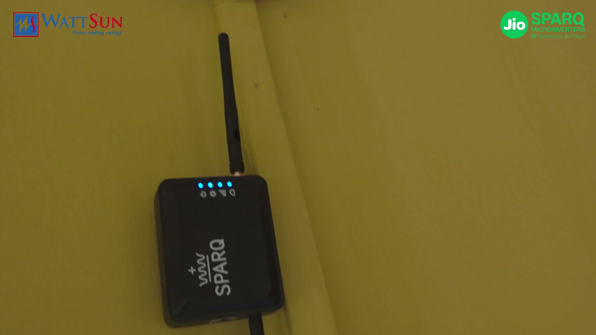 The Sparq gateway on a wall, its antenna up and four status lights lit