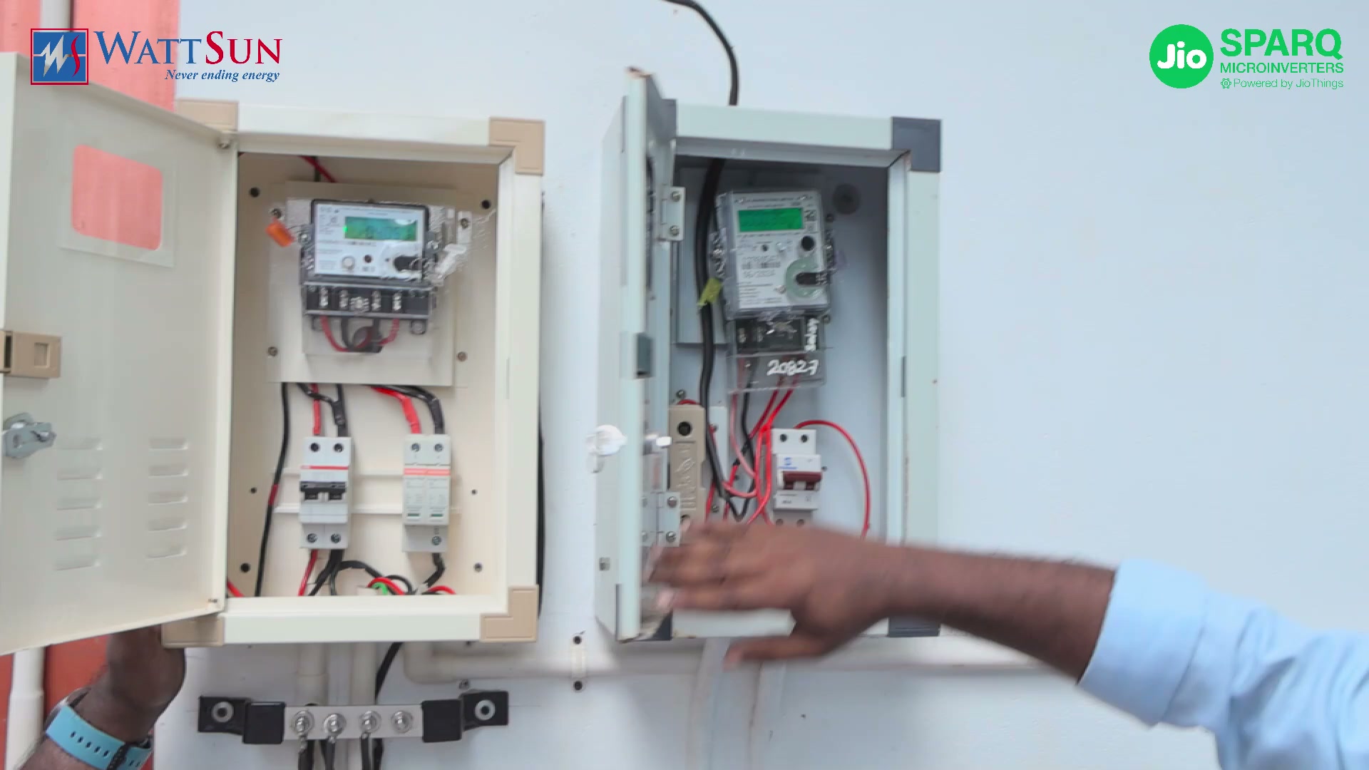 Two open meter boxes on a wall: the utility net meter and the solar meter with its breakers