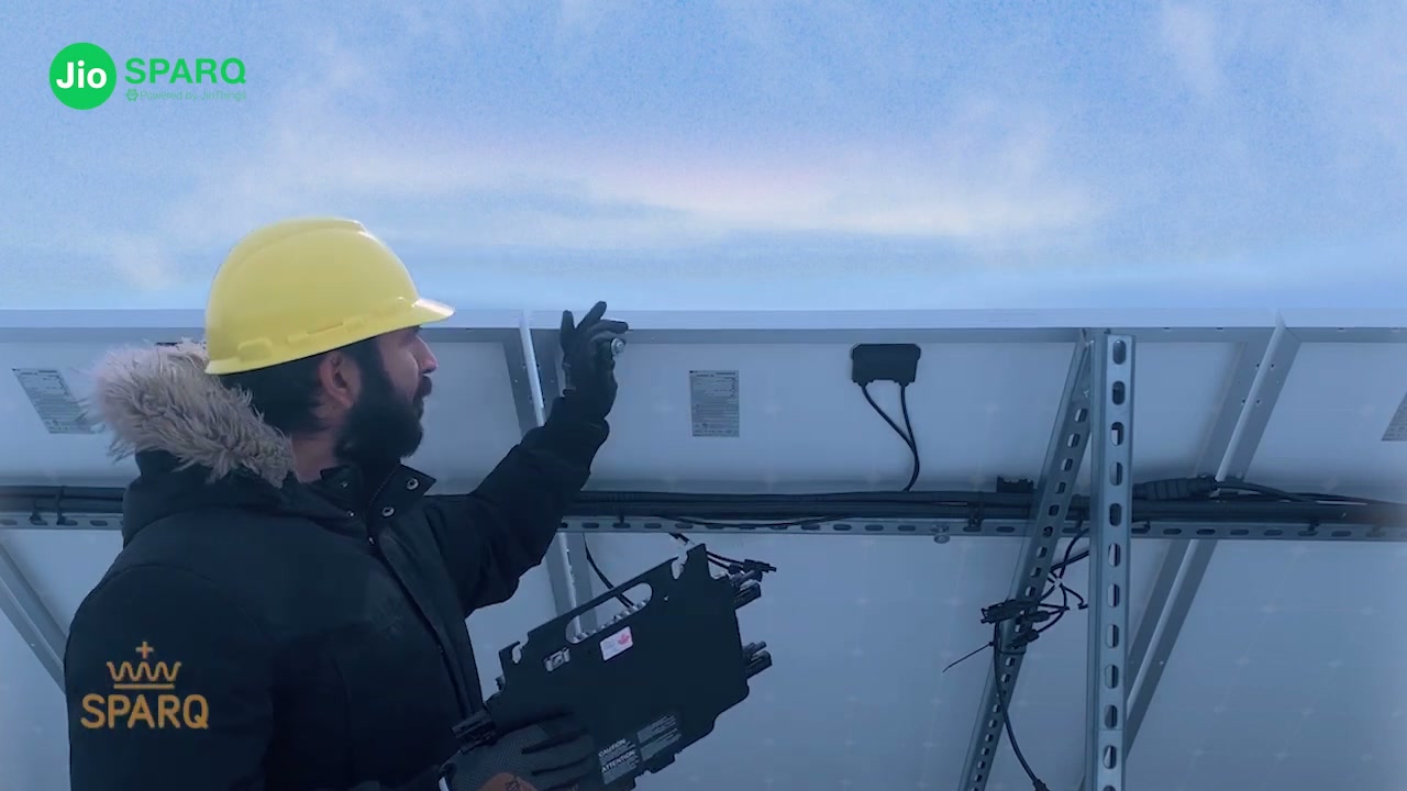 An installer lifting the Quad to the racking against open sky